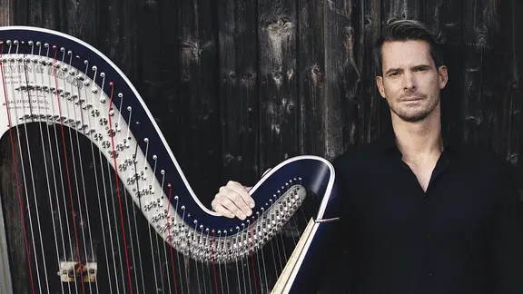 Xavier de Maistre steht neben einer Harfe