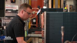 Ein Mann arbeitet in einer Fabrik an einer Wärmepumpe.