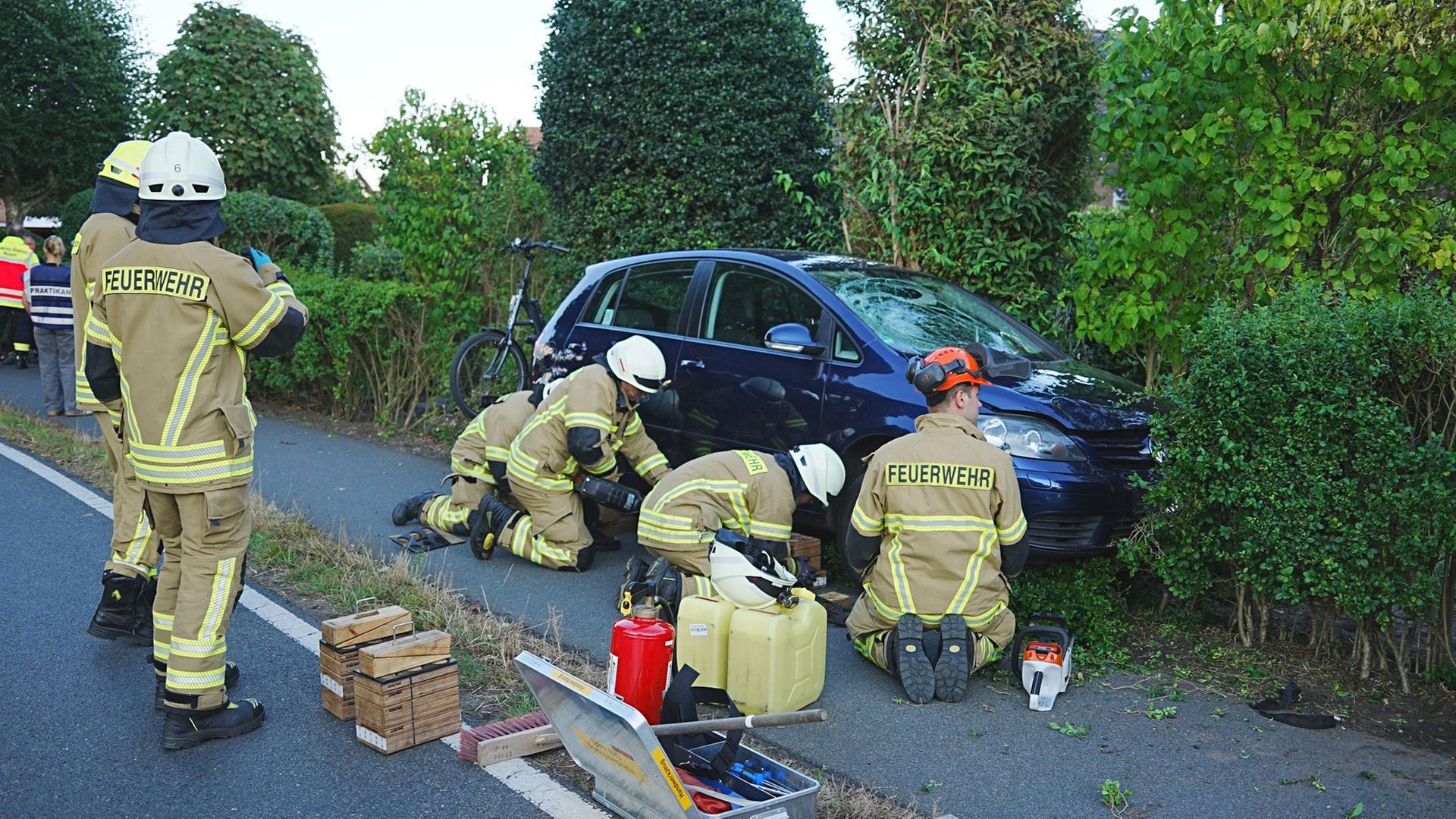 Feuerwehrleute arbeiten an einem verunglückten Pkw. | Nord-West-Media TV