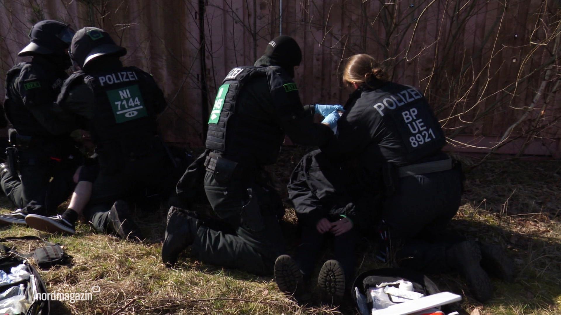 Polizeibeamte üben die Festnahme von aggressiven Demonstranten. | Screenshot