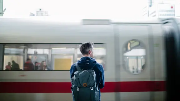 Im Hauptbahnhof Hannover blickt ein Mann auf einen einfahrenden ICE.