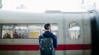 Im Hauptbahnhof Hannover blickt ein Mann auf einen einfahrenden ICE.