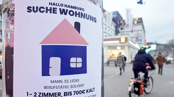 Eine Suchanzeige für eine Wohnung hängt an einem Ampelmast in hamburg.