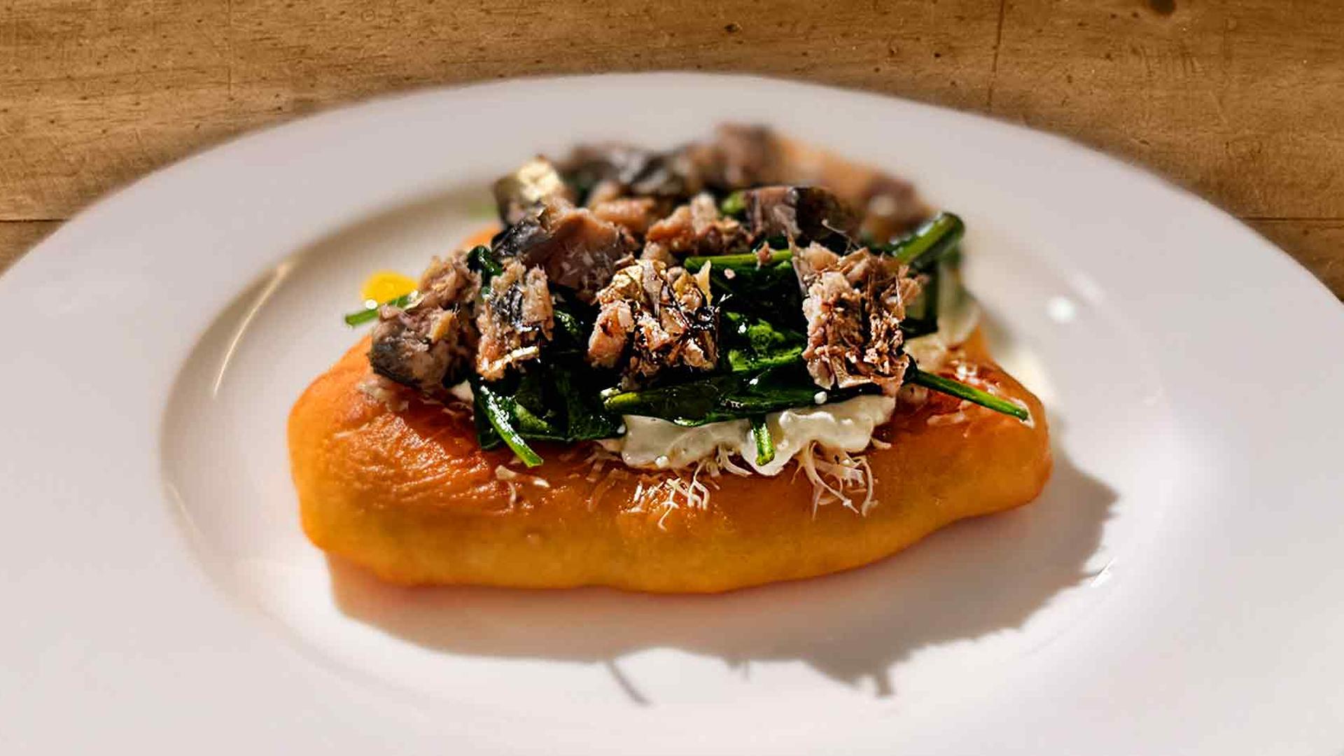 Langos mit Sauerrahm, Spinat und Kieler Sprotten auf einem weißen Teller angerichtet | NDR