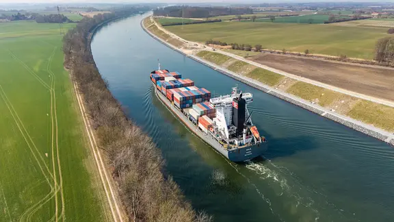Ein Containerschiff fährt durch einen Kanal