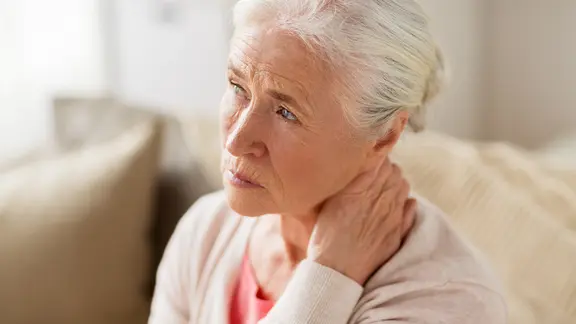 Eine ältere Frau hat Schmerzen.