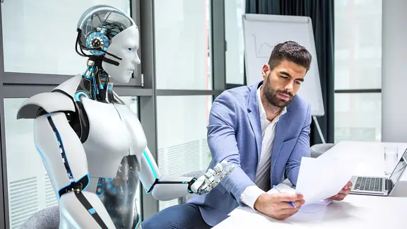 Ein Roboter zusammen mit einem menschlichen Kollegen in einem Büro.