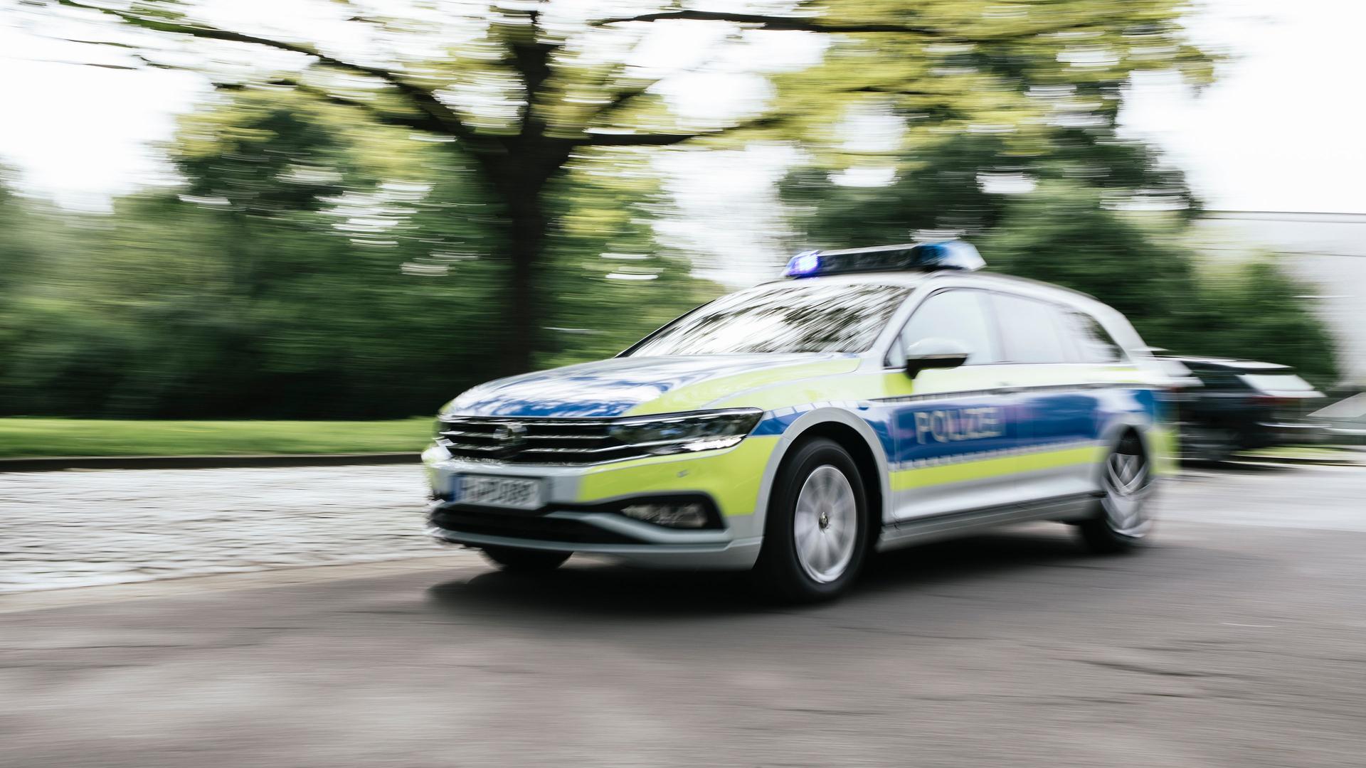 Ein Polizeiauto in Unschärfe fährt mit Blaulicht eine Straße entlang. | NDR, Julius Matuschik