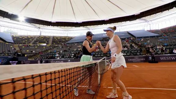Zwei Frauen treten gegeneinander im Tennis an. 