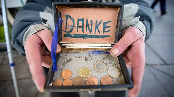In einer Schachtel liegt Kleingeld. Darüber steht "Danke".