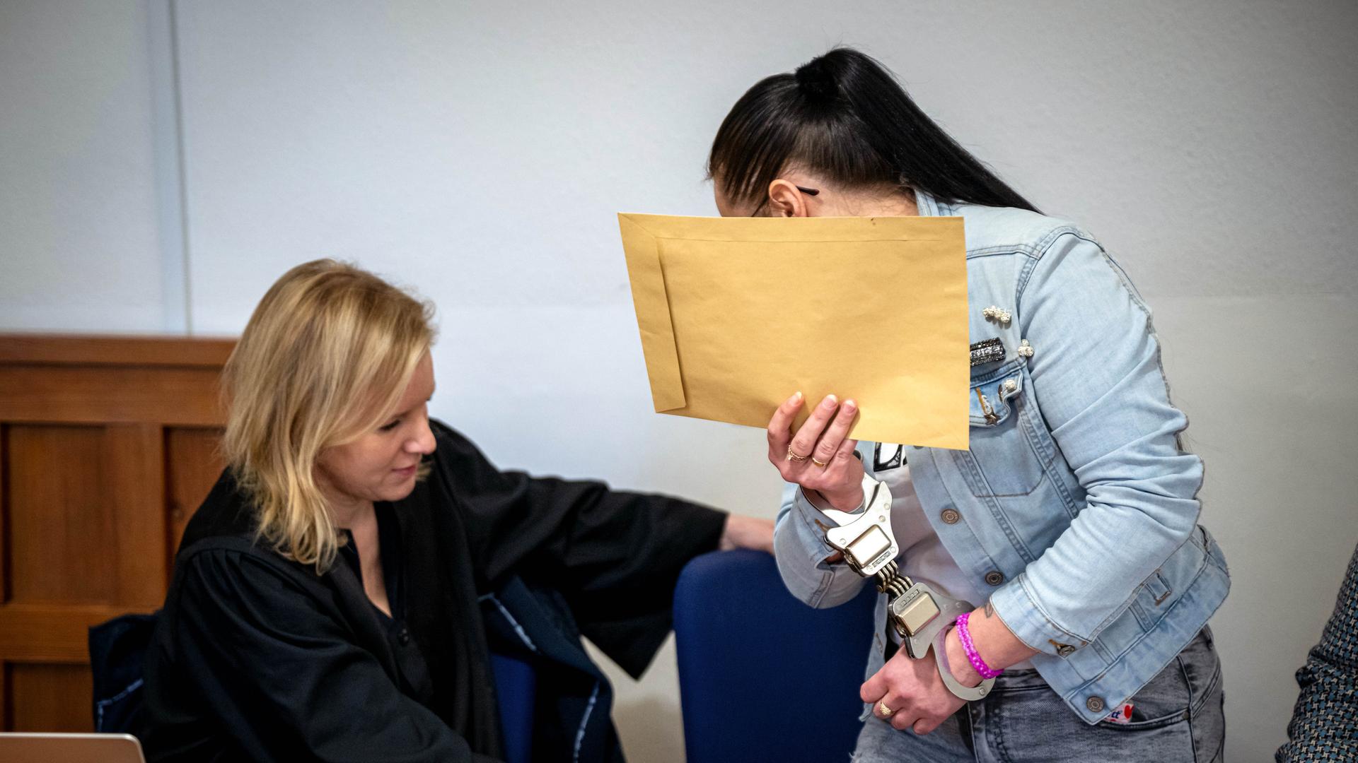 Eine Angeklagte steht neben ihrer Anwältin Sandra Baumann im Gerichtssaal vom Landgericht Oldenburg. | dpa, Sina Schuldt