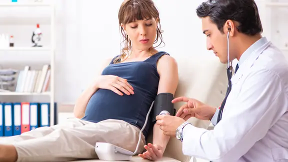 Präklampsie: Schwangere lässt sich beim Arzt Blutdruck messen 