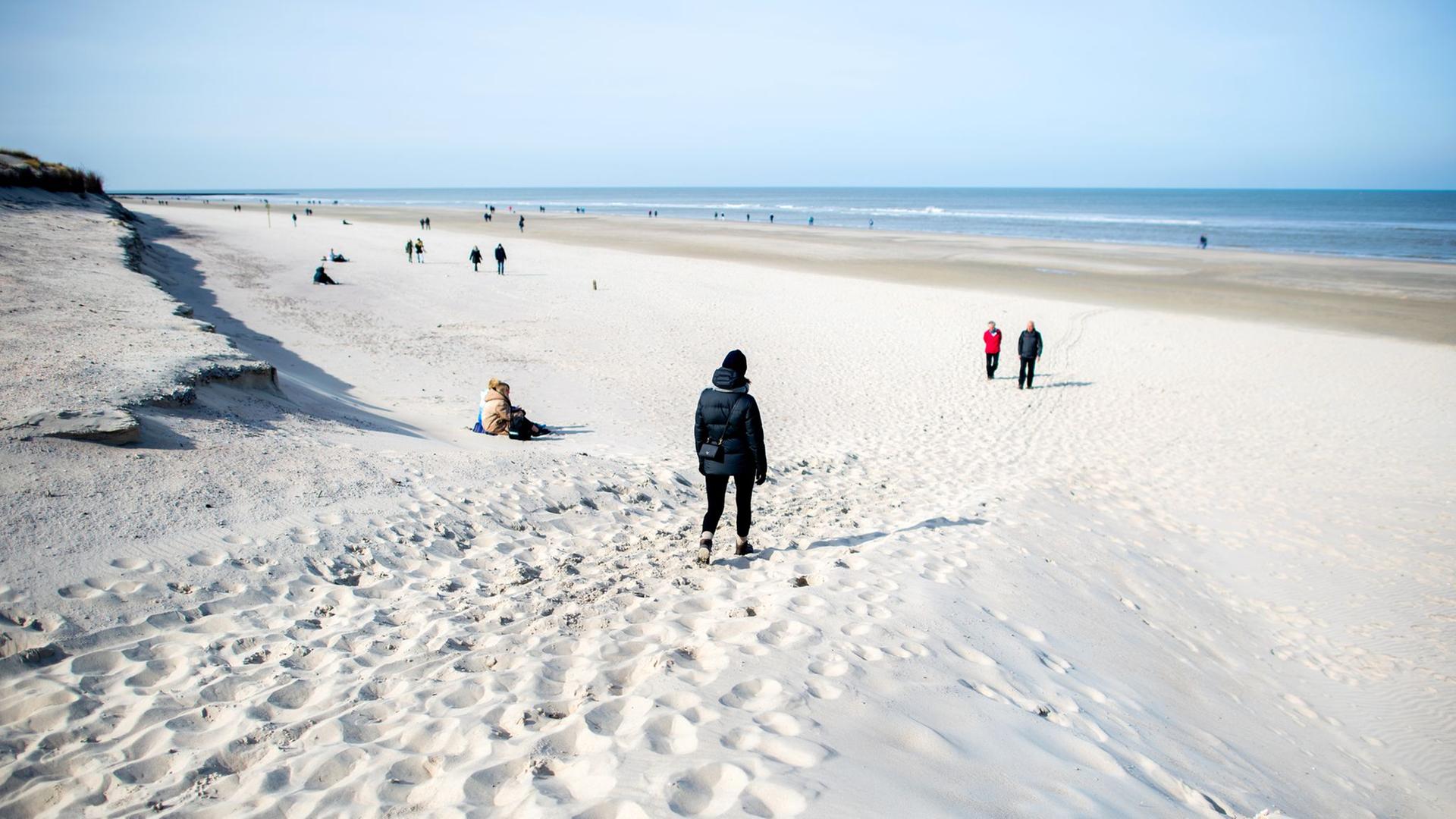 Spaziergänger gehen am Strandabschnitt 