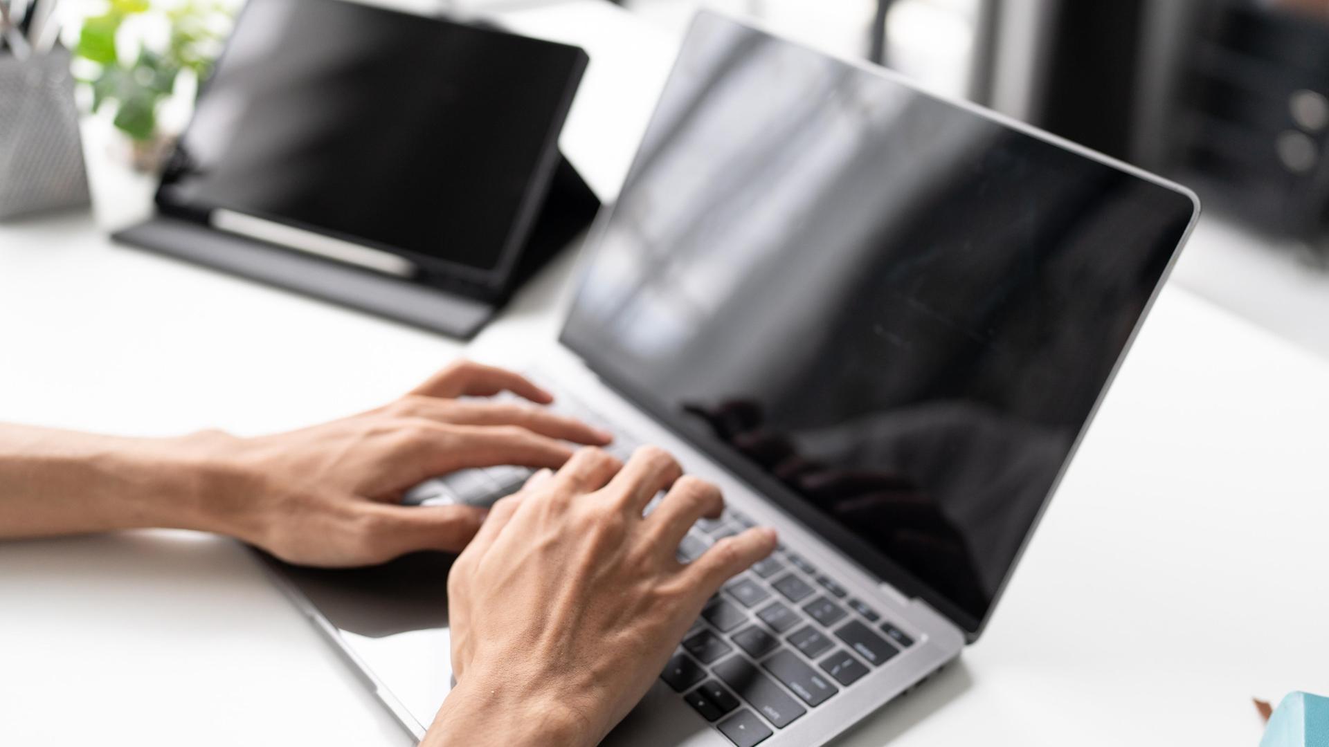 Ein Mann tippt auf der Tastatur eines Laptops. | picture alliance / Zoonar | Sirijit Jongcharoenkulchai