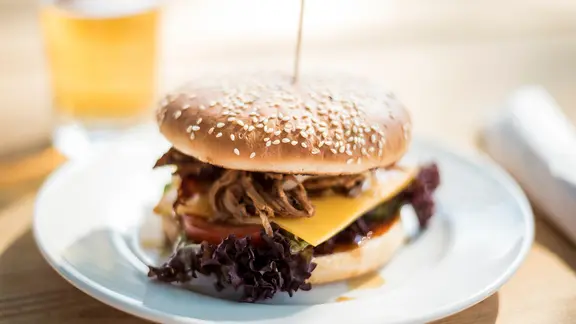 Eine Burger liegt auf einem Teller.