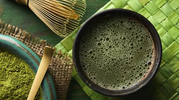 Matcha-Teepulver, ein Bambusbesen und ein Löffel zur Herstellung eines Matcha-Tees | picture alliance / imageBROKER | TONO BALAGUER Matcha-Teepulver, ein Bambusbesen und ein Löffel für eine japanische Zeremonie