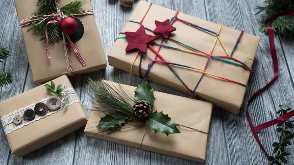 Vier in Packpapier verpackte Geschenke liegen auf einem Tisch. | NDR, Anja Deuble Vier in Packpapier verpackte Geschenke liegen auf einem Tisch.