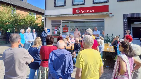 Mehrere Dutzend Menschen versammelten sich vor einer Sparkassenfiliale und demonstrierten gegen die Demontage von Geldautomaten.