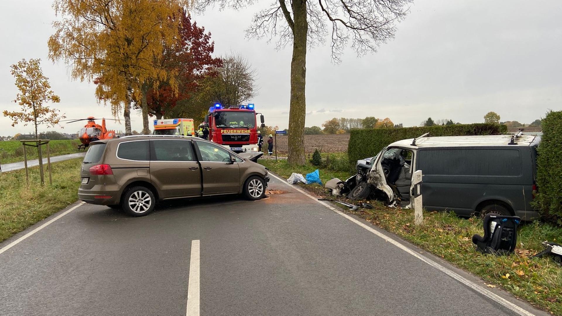 Feuerwehr, Rettungswagen und ein Rettunghubschrauber auf einer Landstraße; im Vordergrund steht ein Auto quer über der Fahrbahn, rechts neben der fahrbahn ein stark beschädigter Transporter | Polizeiinspektion Stade
