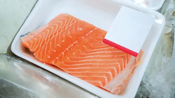 Lachsfilet in einer Styropor-Kunststoffschale mit Plastikfolie.