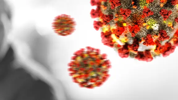 Virensymbole fliegen um die Silhouette einer Person. (Bildmontage)