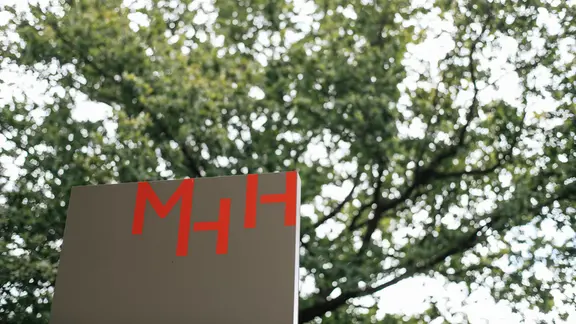 Das Logo der Medizinischen Hochschule Hannover (MHH) auf einer Außentafel.