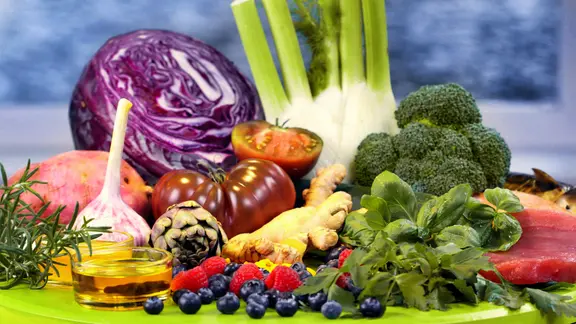 Rotkohl, Fenchel, Brokkoli, Knoblauch, Ingwer, Beeren, zwei Schüsselchen Öl, Thunfischsteak, Lachssteak, Kräuter und Gewürze auf einem Teller.
