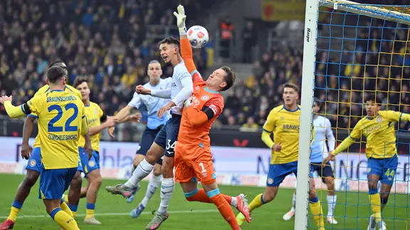 BTSV-Torwart Ron-Thorben Hoffmann machte beim Treffer von Cajetan Lenz keine gute Figur. | picture-alliance/dpa | Swen Pförtner Bochums Cajetan Lenz punktet 0:1 gegen Braunschweigs Ron-Thorben Hoffmann