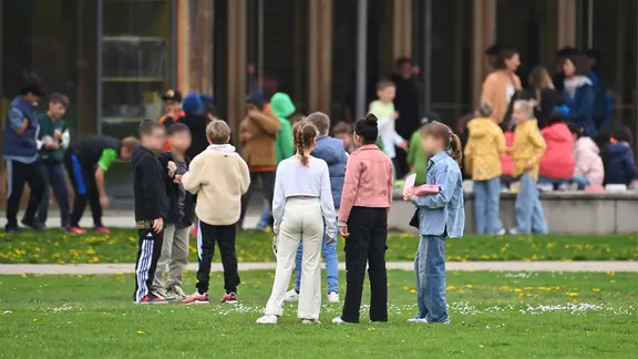 Kinder stehen auf dem Schulhof.