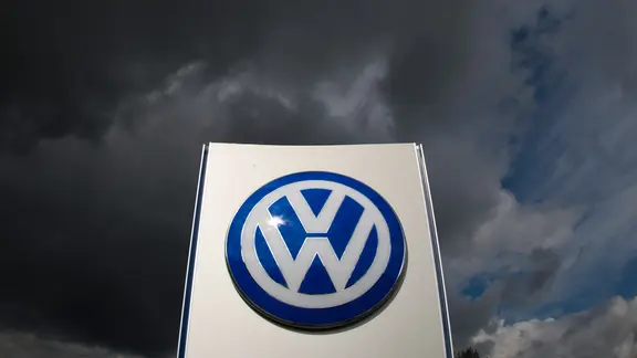 Dunkle Wolken ziehen über ein VW-Logo