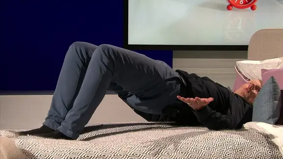 Bewegungs-Doc Helge Riepenhof zeigt Übungen auf dem Bett. | NDR Bewegungs-Doc Helge Riepenhof zeigt Übungen auf dem Bett.