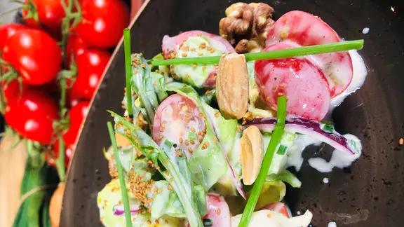 Salat mit Joghurt-Dressing auf einem Teller.