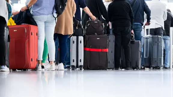 Reisende mit Handgepäck-Taschen