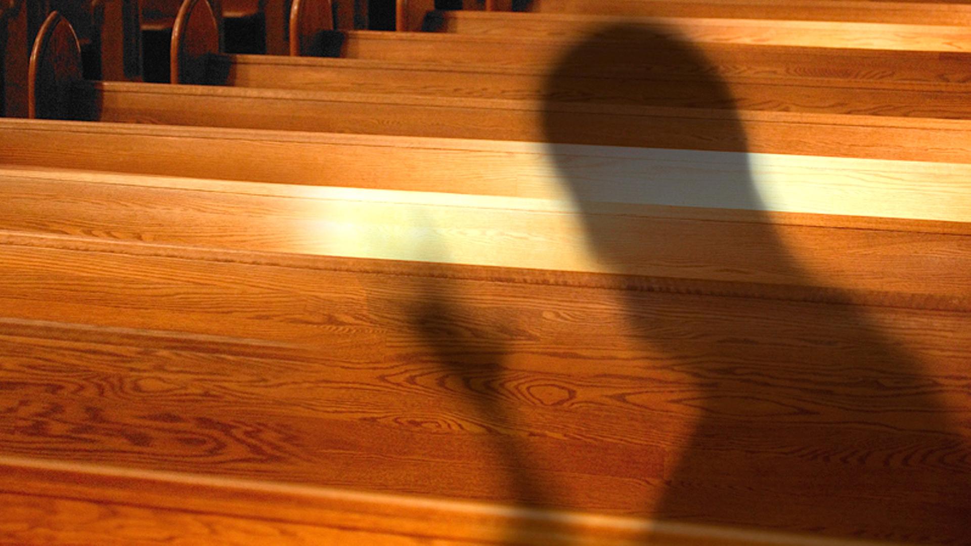 Montage: Bedrohlicher Schatten vor Kirchenbänken. | Bänke: picture-alliance / Design Pics, Schatten: sasha_Fotolia.com_2112135, Bänke: picture-alliance / Design Pics, Schatten: sasha_Fotolia.com_2112135