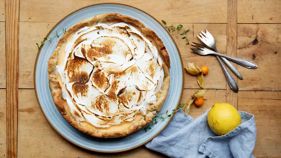 Zitronentarte mit Baiser-Haube auf einer Platte serviert