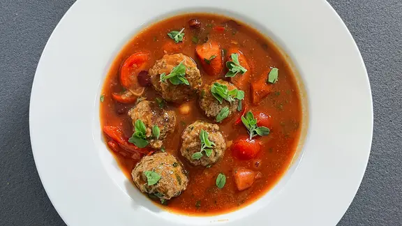 Bohnen-Eintopf in einem weißen tiefen Teller angerichtet