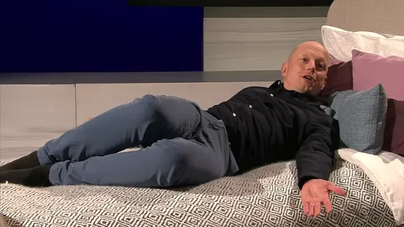 Bewegungs-Doc Helge Riepenhof zeigt Übungen auf dem Bett. | NDR Bewegungs-Doc Helge Riepenhof zeigt Übungen auf dem Bett.