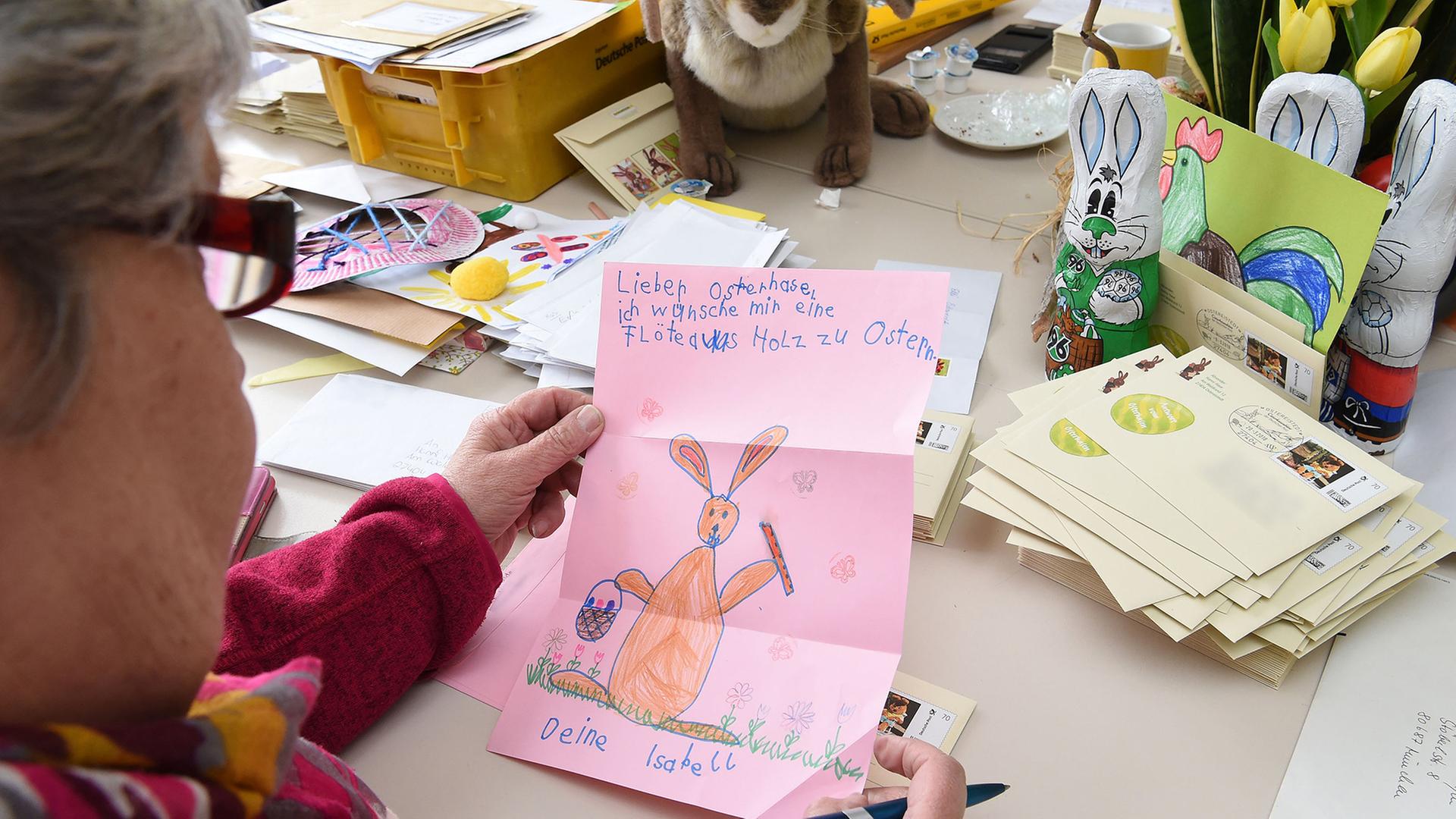 Eine Frau liest einen Brief im Postamt von Hanni Hase. | dpa-Bildfunk, Carmen Jaspersen