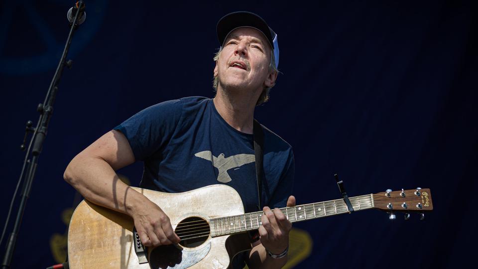 Der deutsche Singer-Songwriter, Podcaster, Schauspieler und Moderator Olli Schulz spielt auf einer Bühne beim Hurricane Festival 2025 Gitarre und singt in ein Mikrofon.