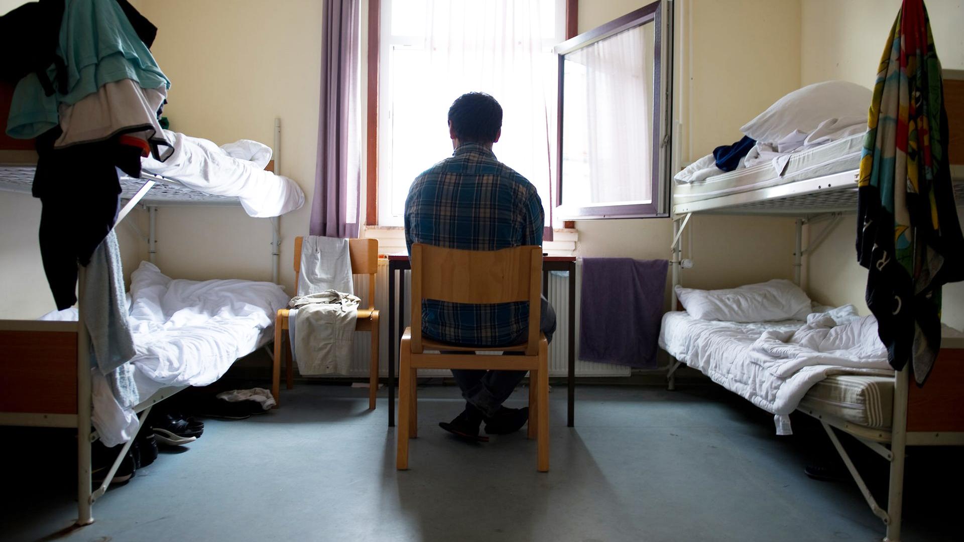 Ein Flüchtling sitzt in Friedland in einer Unterkunft. | picture alliance/dpa , Swen Pförtner