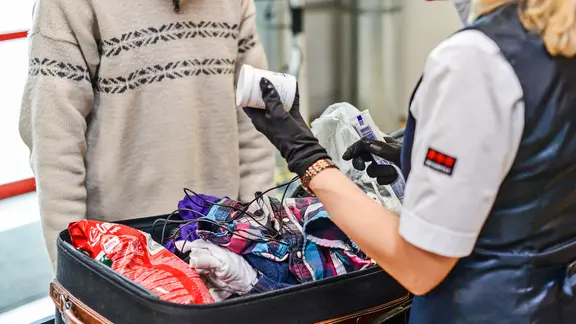 Der Kofferinhalt eines Reisenden wird an der Sicherheitskontrolle am Flughafen geprüft. | picture alliance / dpa-Zentralbild, Jens Kalaene Der Kofferinhalt eines Reisenden wird an der Sicherheitskontrolle am Flughafen geprüft.