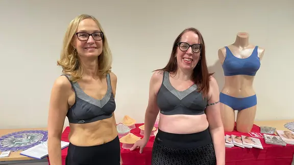 Steffi Behrke and Almuth Bibow present prosthetic bras at a fashion show in a hospital. | NDR, Lydia Callies Steffi Behrke and Almuth Bibow present prosthetic bras at a fashion show in a hospital.