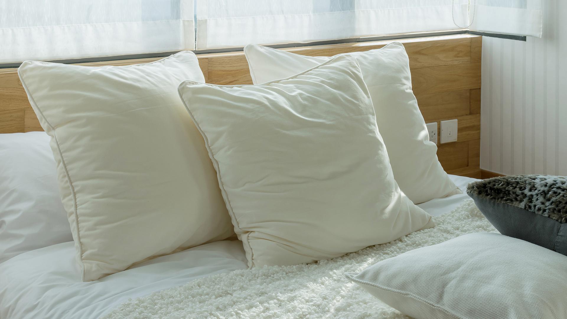 Drei Kissen liegen auf einem Bett. | Colourbox, #241139