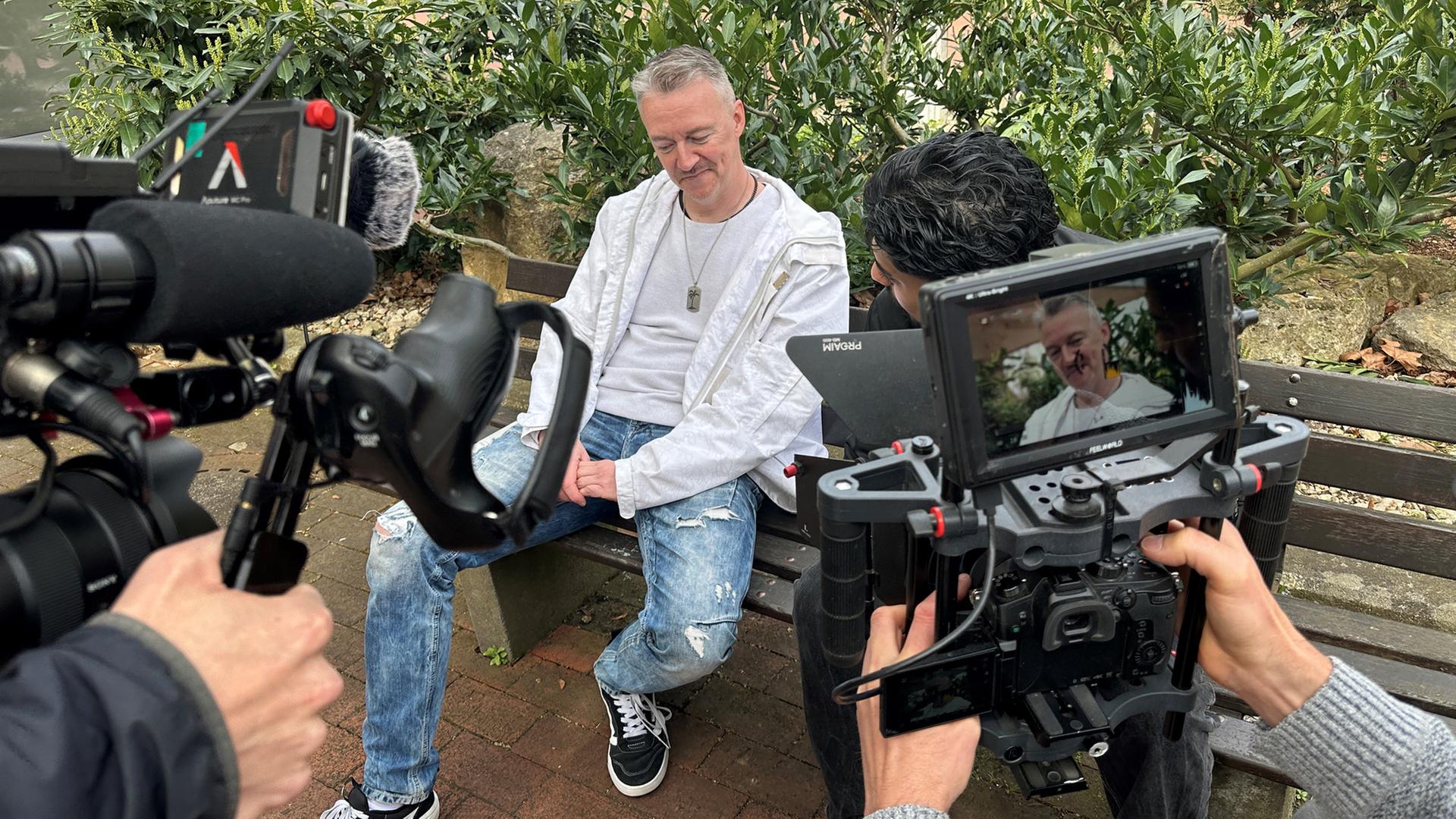 Zwei Männer sitzen auf eine Bank und werden dabei gefilmt. | NDR, Doretta Farnbacher
