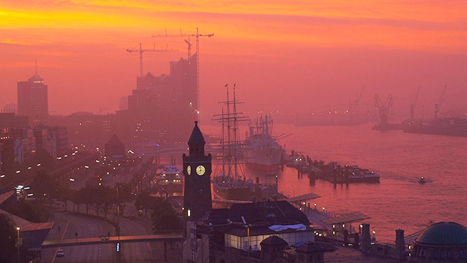 Die geneigte Erdachse beschert uns auf der Nordhalbkugel im Sommer lange Tage, im Winter dagegen lange Nächte. | Deutscher Wetterdienst Sonnenaufgang über dem Hamburger Hafen