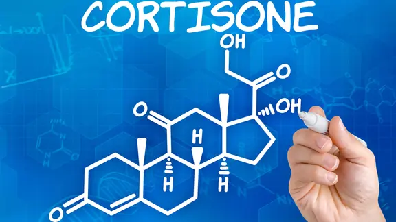 Kortison: Hand schreibt Kortisonmolekül auf Tafel