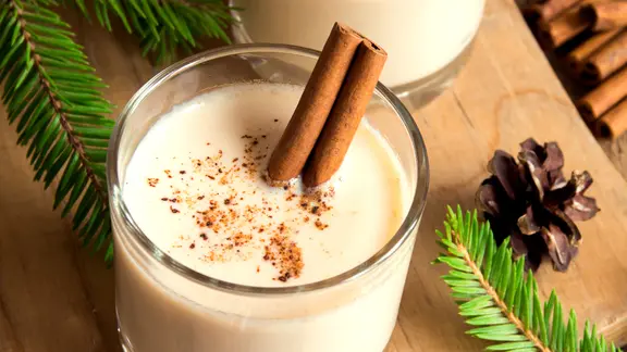 Mit Sahne wird der Glühwein zu einem cremig-süßen, wärmenden Getränk. | Colourbox, - Ein Glas Glühwein mit Sahne und Gewürzen.