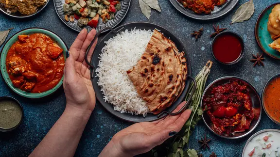 Ein Tisch mit einer Schüssel Reis und diversen gefüllten Schälchen.