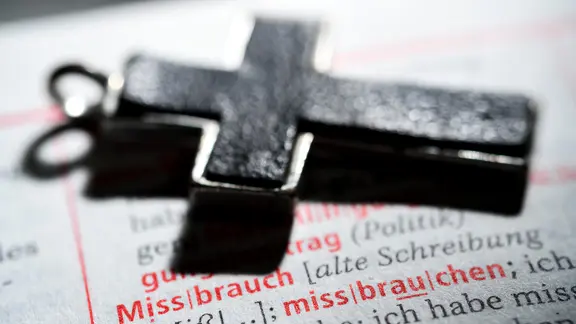 Kreuz auf einem Wörterbuch mit dem Wort Missbrauch.