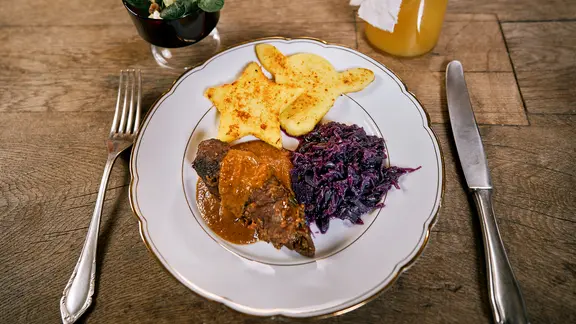 Rinderrouladen mit gebratener Polenta und Rotkohl auf einem Teller serviert